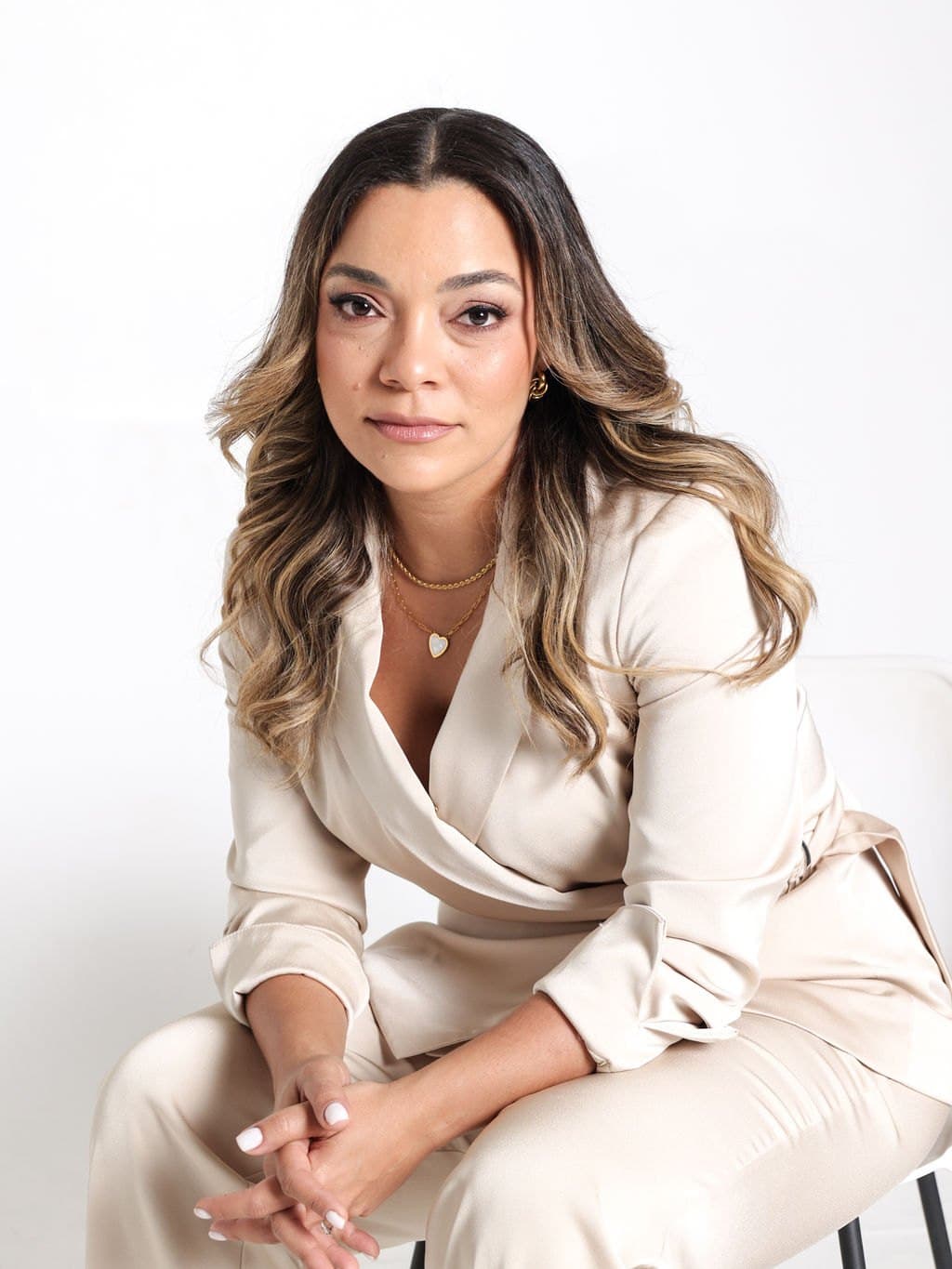 Anji Santiago sentada con traje claro